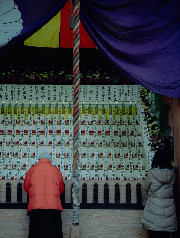 Two visitors at a shrine in winter.